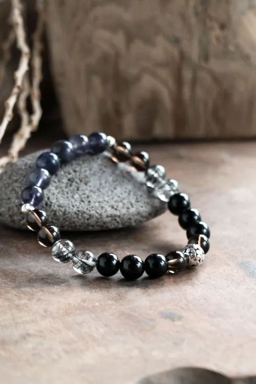 Close-up of polished obsidian jewelry showing reflections