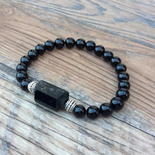 Obsidian flow at Glass Butte, Oregon, contrasting against rocky terrain