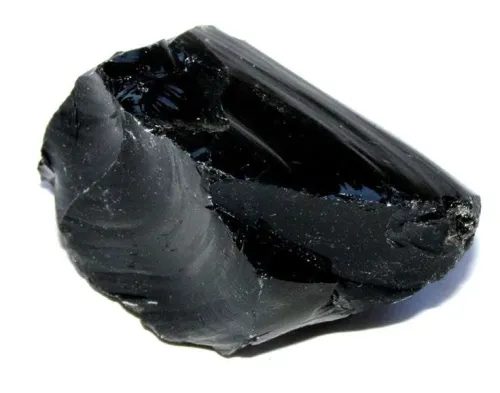 Obsidian stone held at an angle showing translucency against light